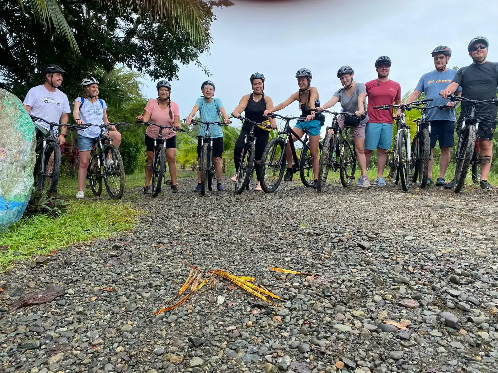 Group of cyclists in helmets standing with mountain bikes on a gravel road