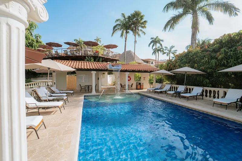Pool deck with palm trees at Parador